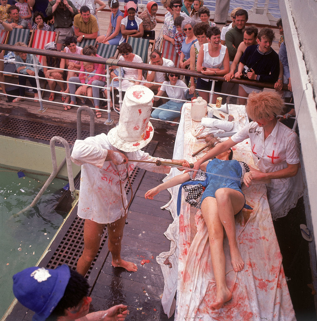 Detail of Macabre comic entertainment aboard an unspecified cruise ship, with a female passenger prostrate on a bloody slab - perhaps a variant of the Crossing the Line (the Equator) ceremony? by Marine Photo Service