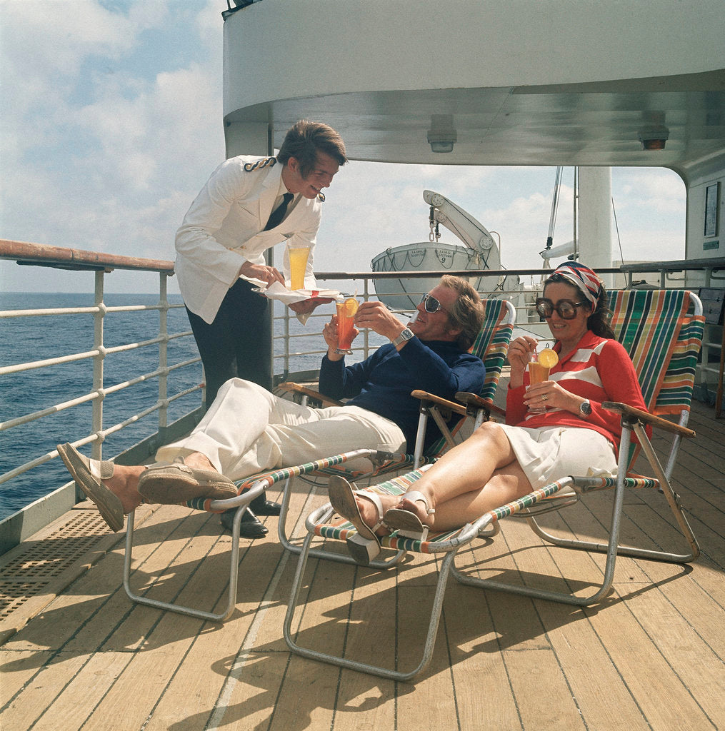 Detail of A ship's steward serves drinks to passengers on deck by Marine Photo Service