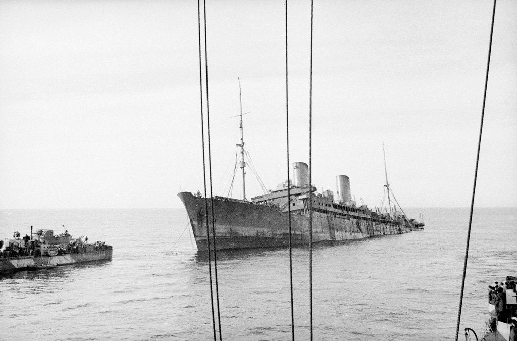 Detail of Photograph of 'Windsor Castle' sinking in 1943. Port bow view well down by the stern with the escort destroyer 'Farndale' (1940) near the bow. by Lt EJ Manners