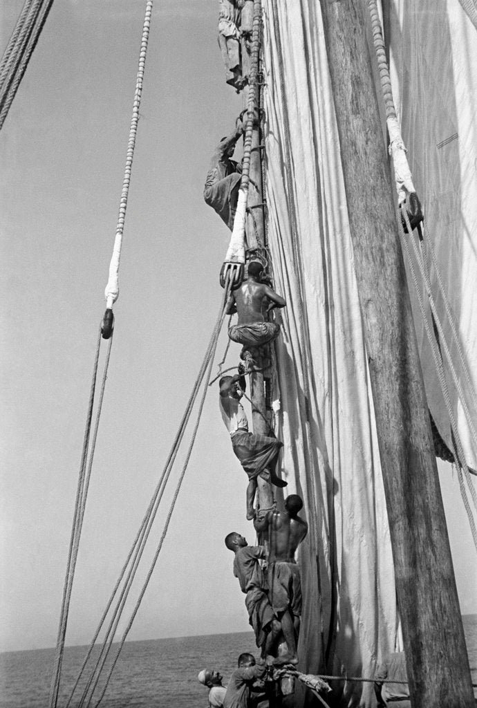 Detail of Kuwaiti sailors climbing aloft and working on the lateen yard by Alan Villiers