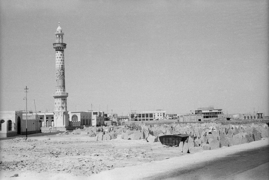 Detail of Minaret, stacked building stone and new buildings, Manama by Alan Villiers